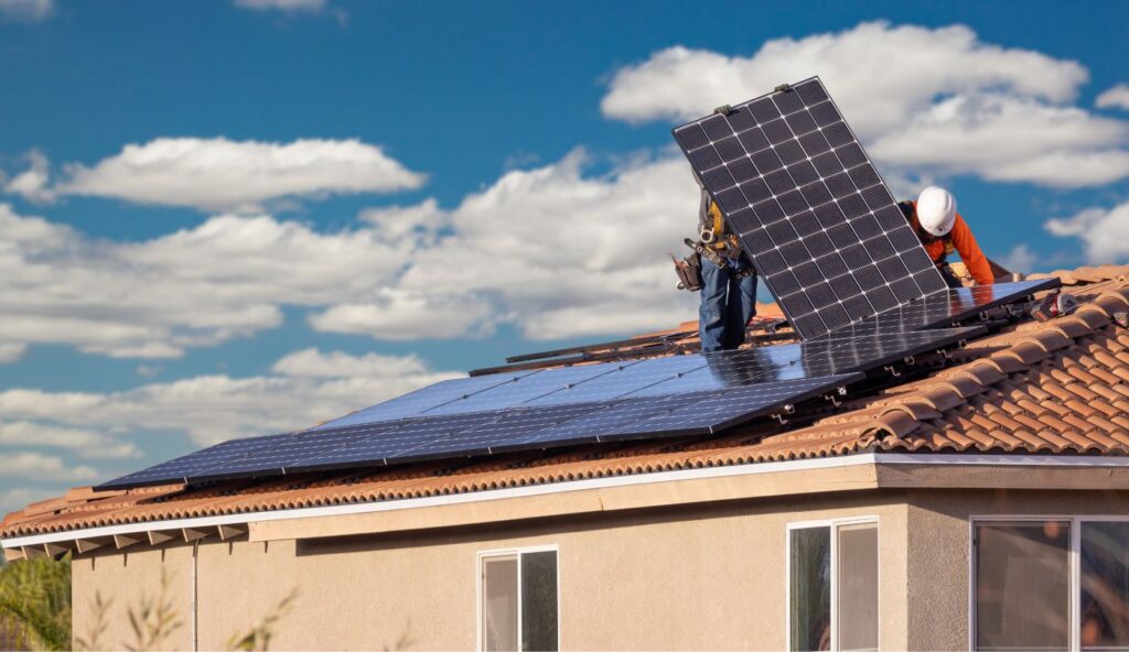 Technician preparing to remove rooftop solar panels before a roof replacement in Northern Utah