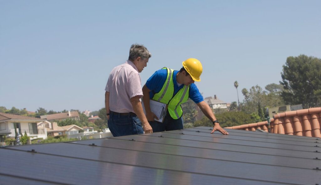 SwiftSolar D&R team inspecting rooftop solar panels before removal for an insurance-covered roof repair in Northern Utah