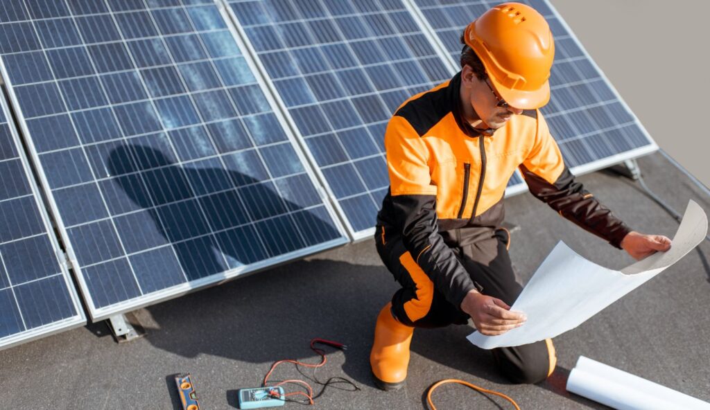 Technician detaching rooftop solar panels before roof replacement