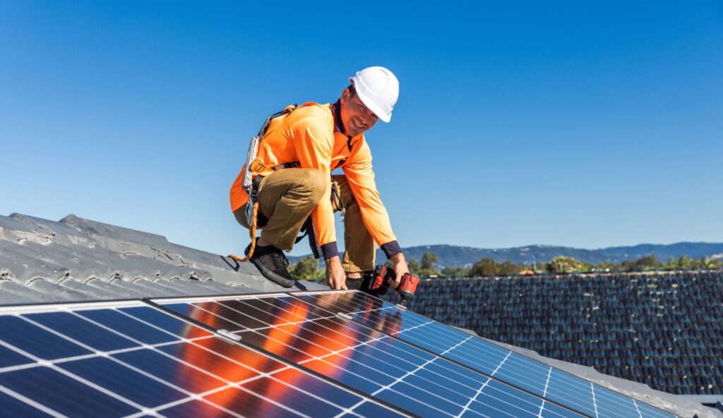Technician and roofer discussing panel removal on rooftop in Northern Utah