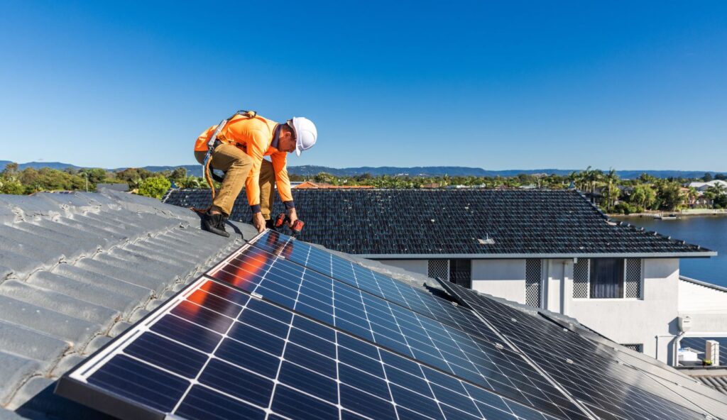Contractor shaking hands with solar crew next to a home under roof work