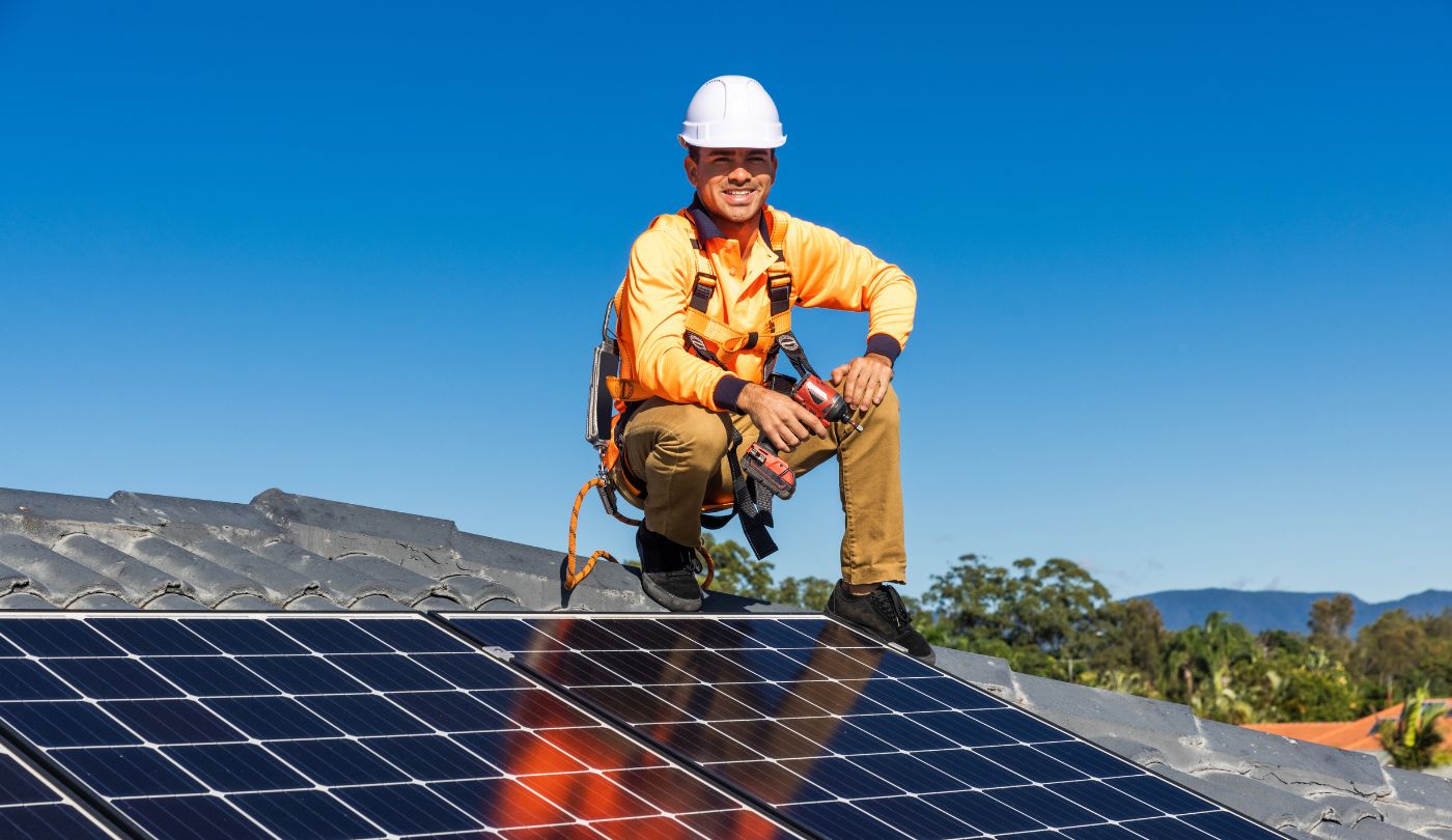 Homeowner looking concerned next to a roof with both solar panels and roofing materials exposed